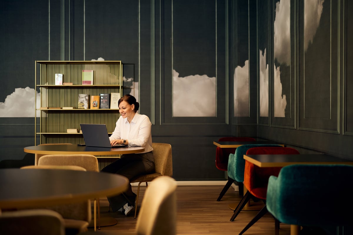 Businesswoman working on laptop in modern cafe